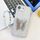 Per iPhone 16e placcatura pellicola lente glitterata texture farfalla supporto cinturino custodia per telefono (modello conchiglia bianca) Per iPhone 16e placcatura pellicola lente glitterata texture farfalla supporto cinturino custodia per telefono (modello conchiglia bianca)