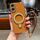 Per iPhone 16 Charm Eye Custodia per telefono con supporto in metallo galvanico con cordino (marrone)